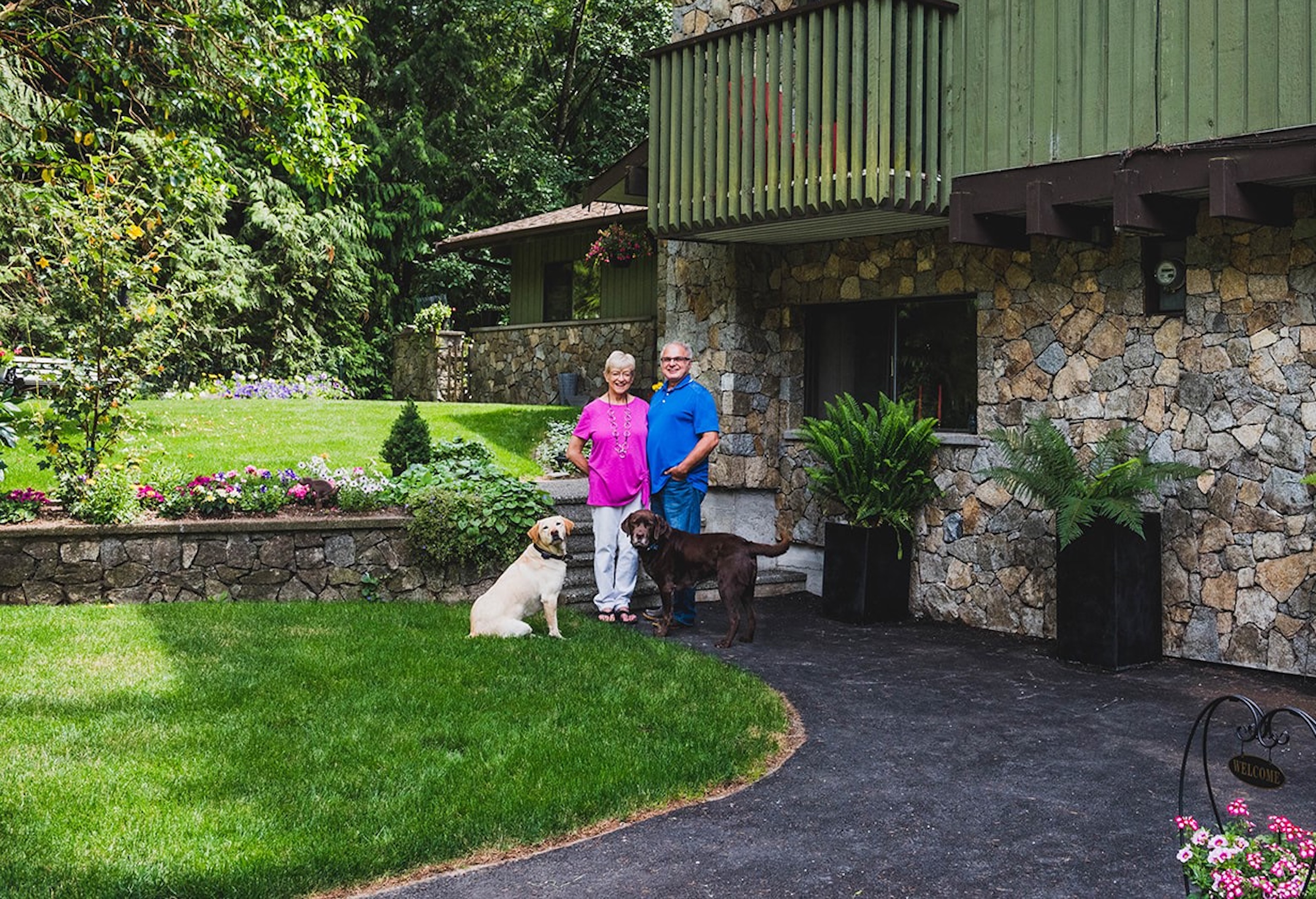 Owners of Misty Meadows Bed & Breakfast standing outside of the building with their dog.